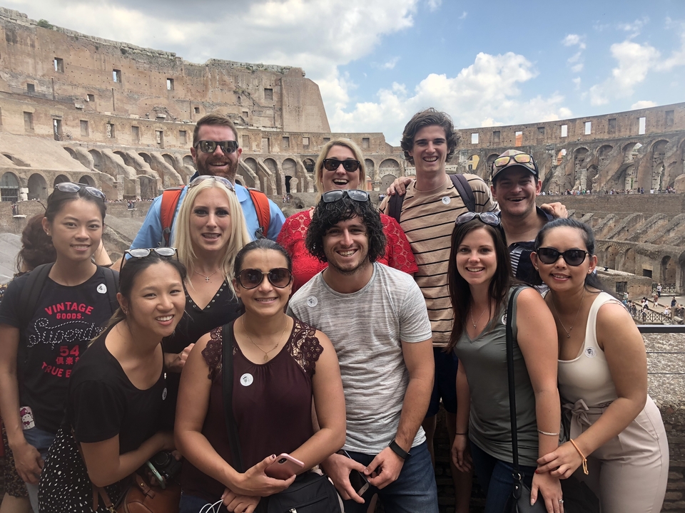 Group photo inside the Colosseum with excited tourists.
