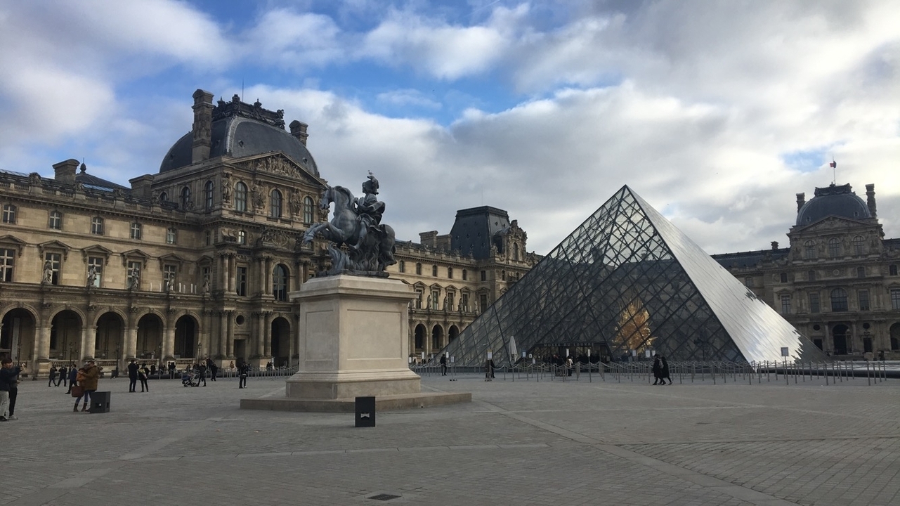 Le musée du Louvre avec sa pyramide de verre et sa statue de cheval à Paris.