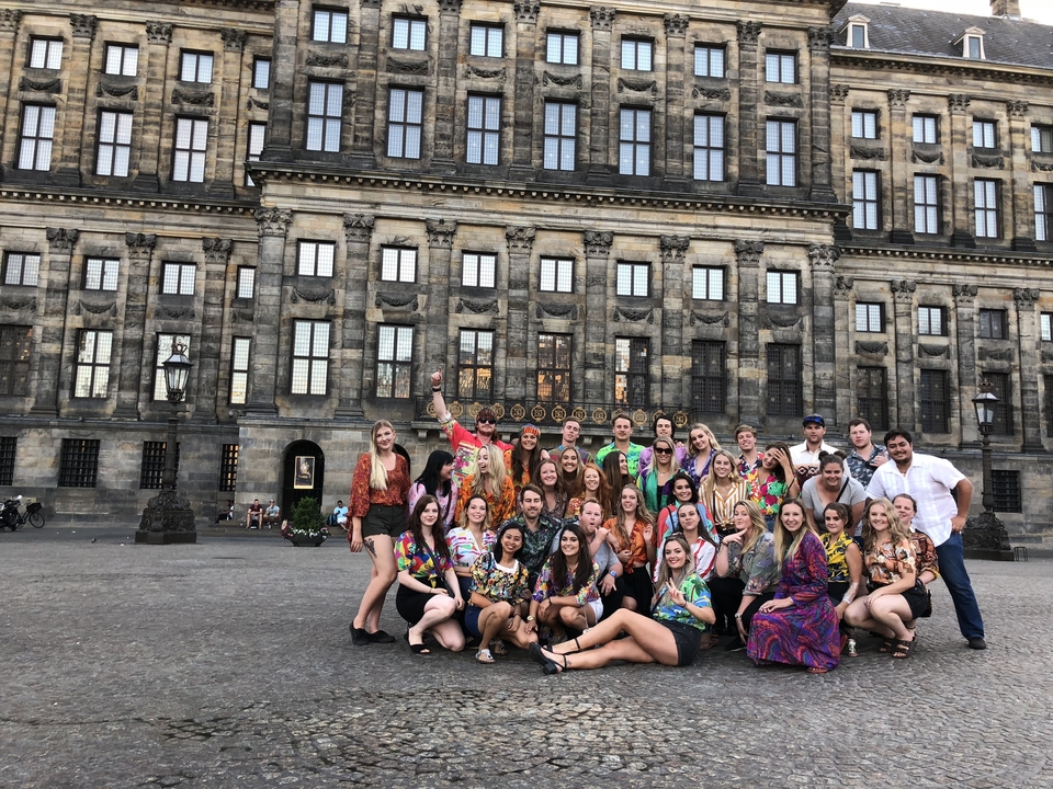 Groupe de personnes devant un bâtiment historique.