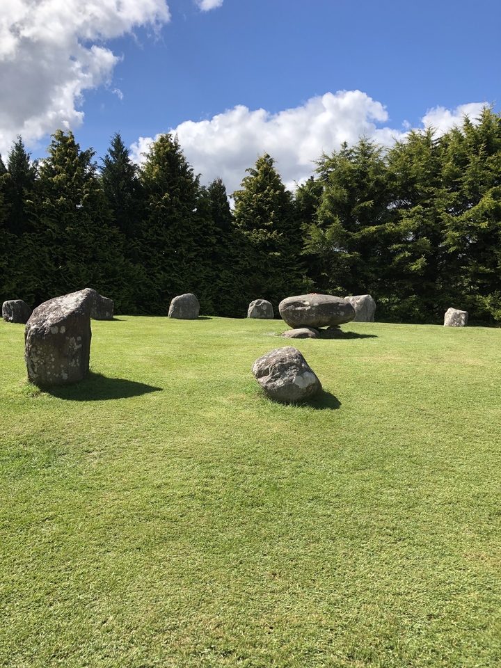 Circular stone formations in a grassy area.