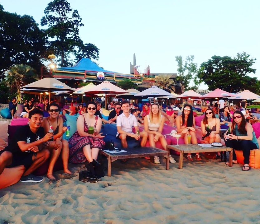 Groupe de personnes assises qui savourent des boissons au bord de la plage.