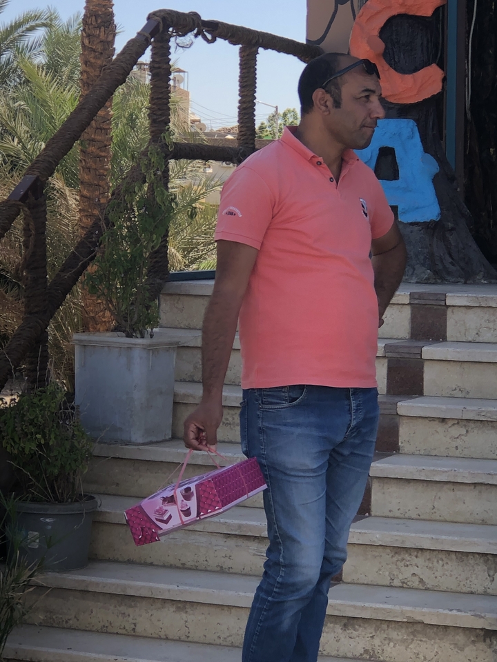 Une personne debout sur des escaliers tenant un sac rose.