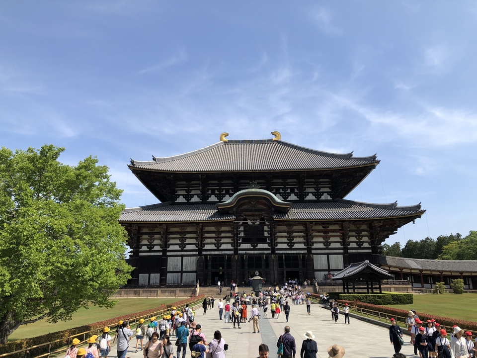 Large traditional Japanese temple with people around.