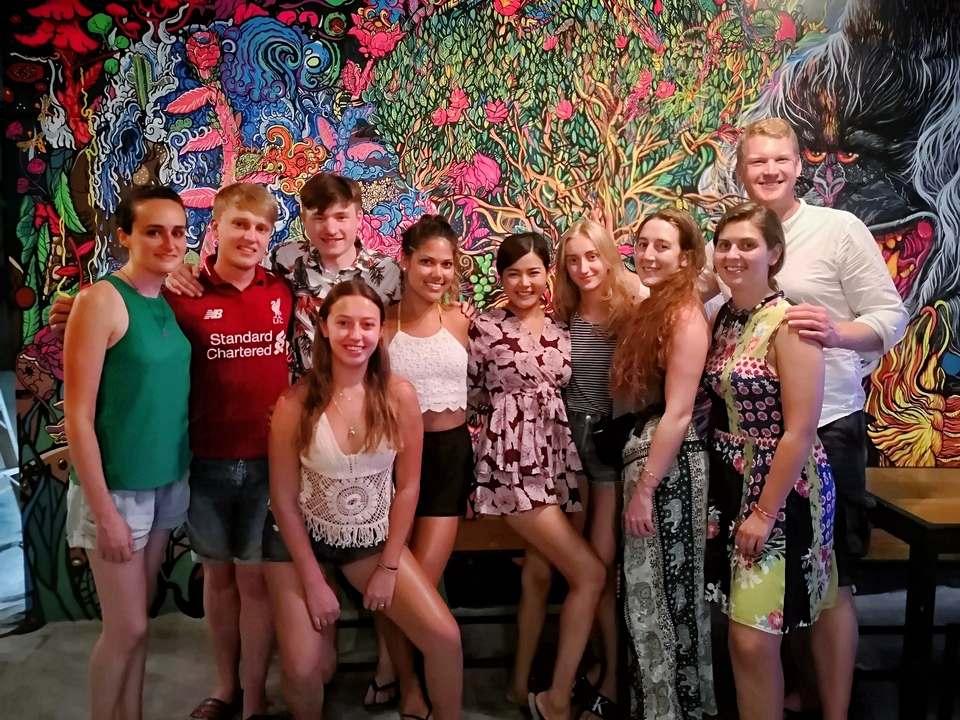 Groupe de personnes posant à l'intérieur avec de l'art mural décoratif