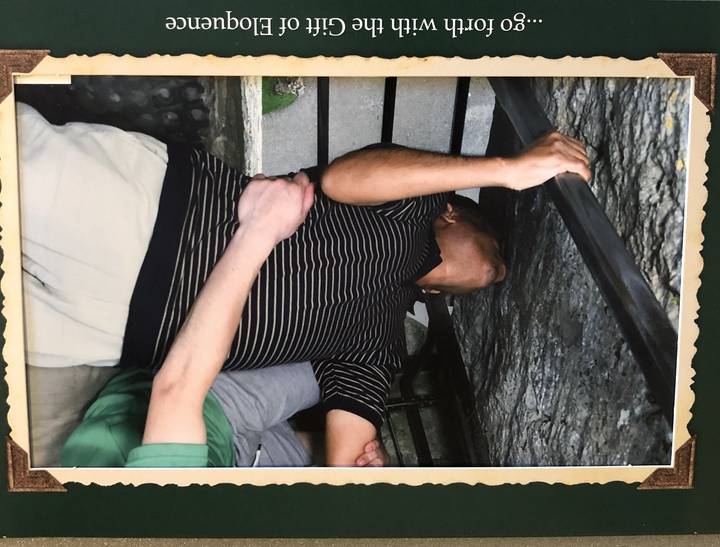 Personne en chemise rayée avec une autre qui la tient.