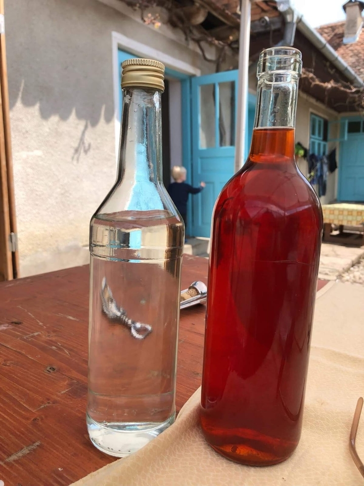 Des bouteilles avec du liquide sur une table, un enfant en arrière-plan.