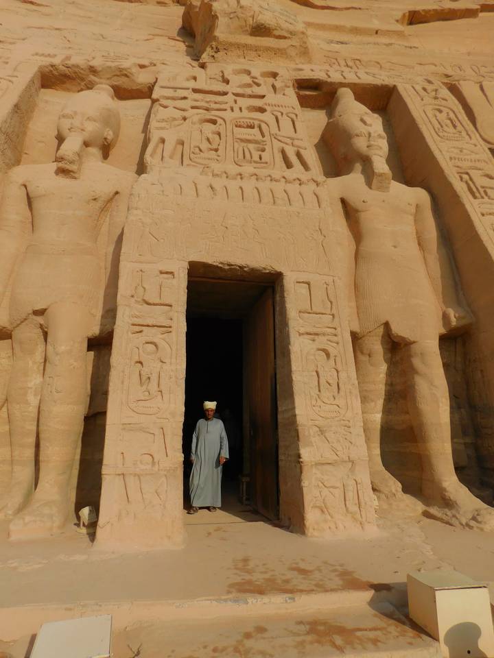 Person in front of an ancient carved temple entrance.