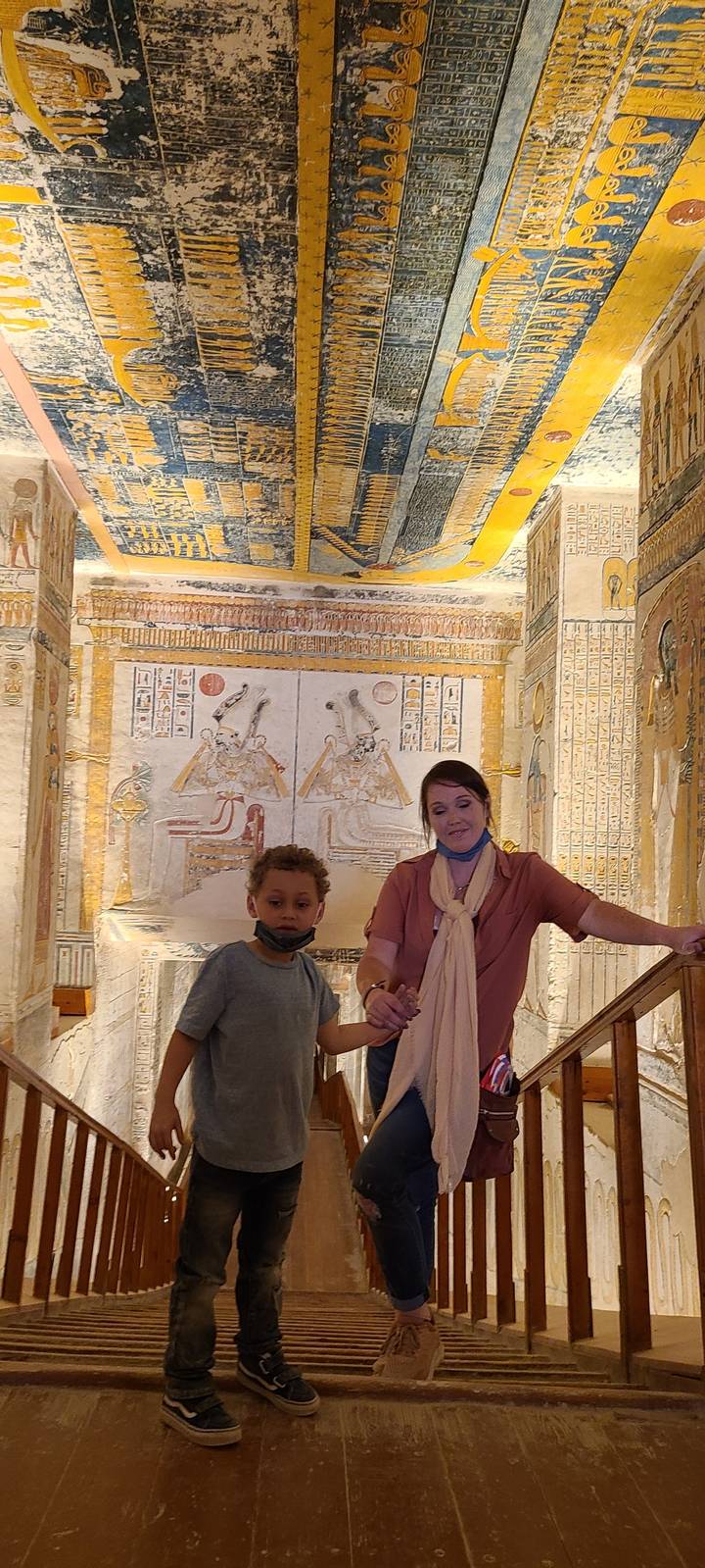 Two people inside a tomb with Egyptian hieroglyphs.