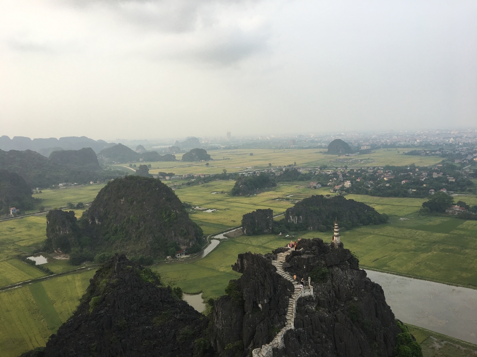 Panoramic view of a landscape with limestone mountains and rice fields.