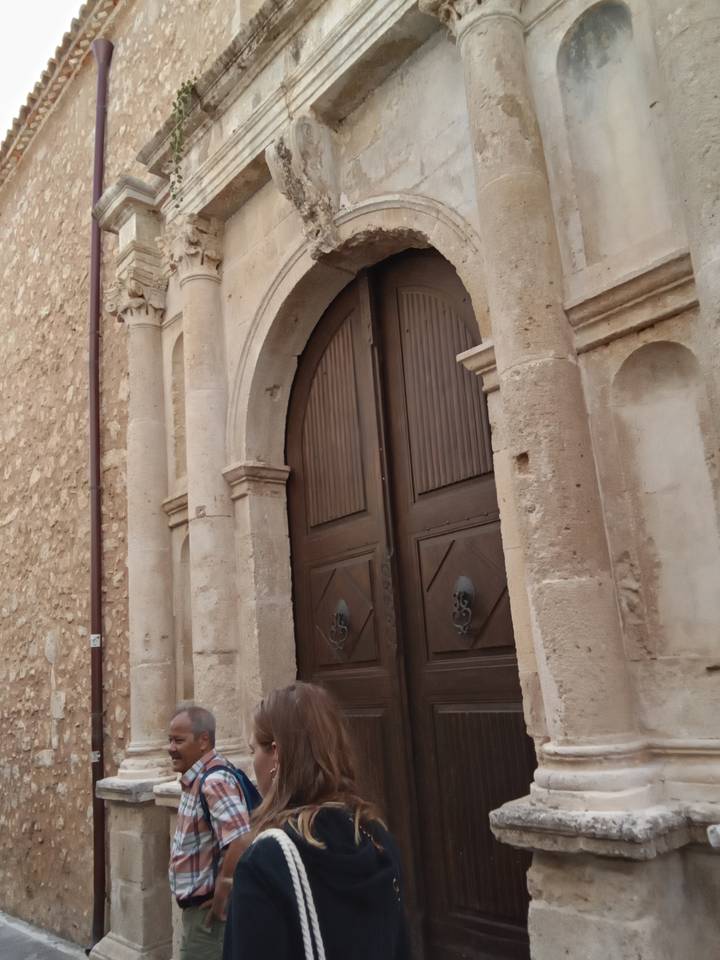 Deux personnes debout devant une vieille porte voûtée