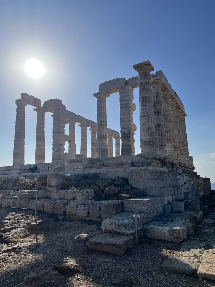 Ruines d'un temple grec antique sous un soleil éclatant.