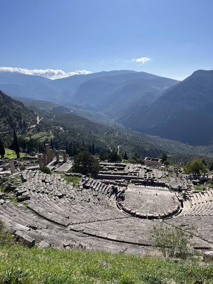 Amphithéâtre grec antique avec des montagnes derrière.