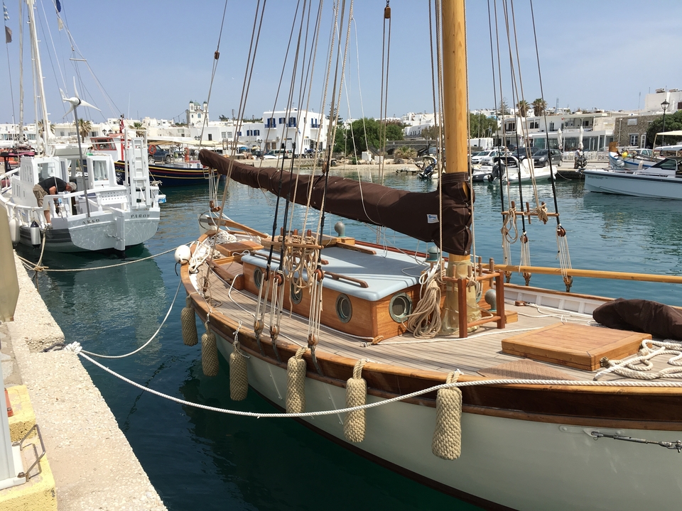 Bateau à voile en bois à un quai avec une eau claire.