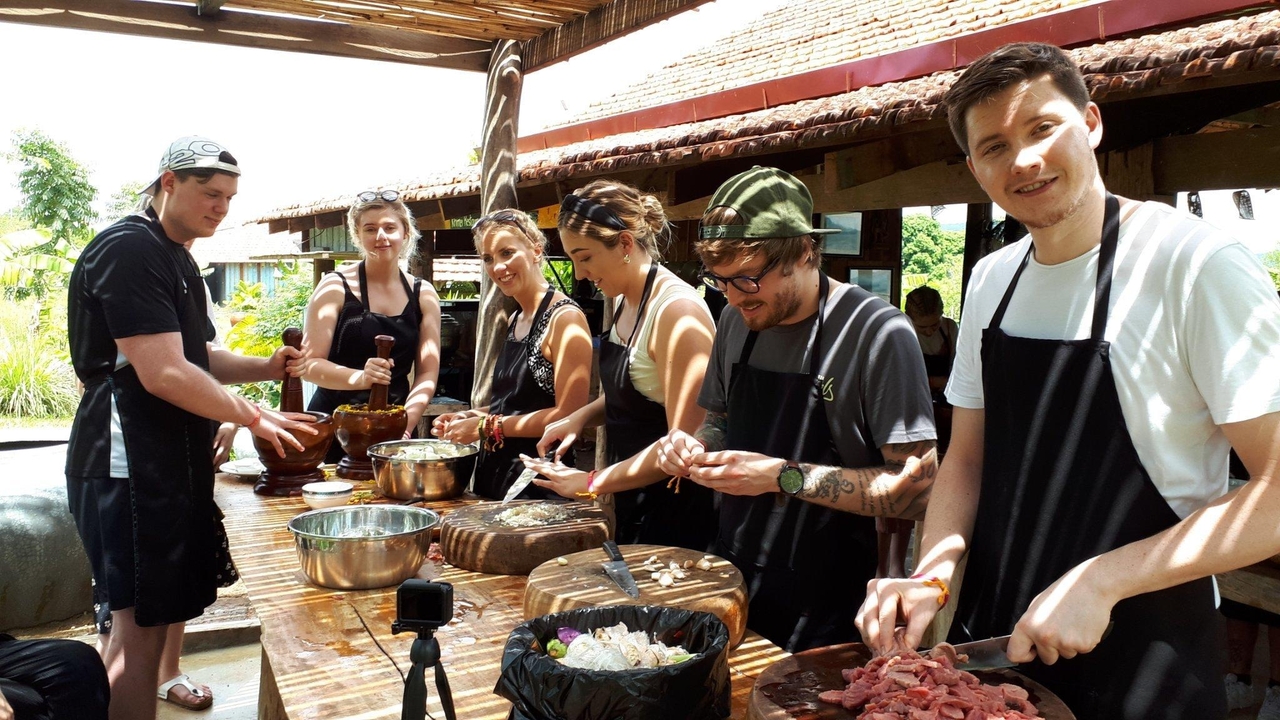 Cours de cuisine avec des participants préparant de la nourriture ensemble.