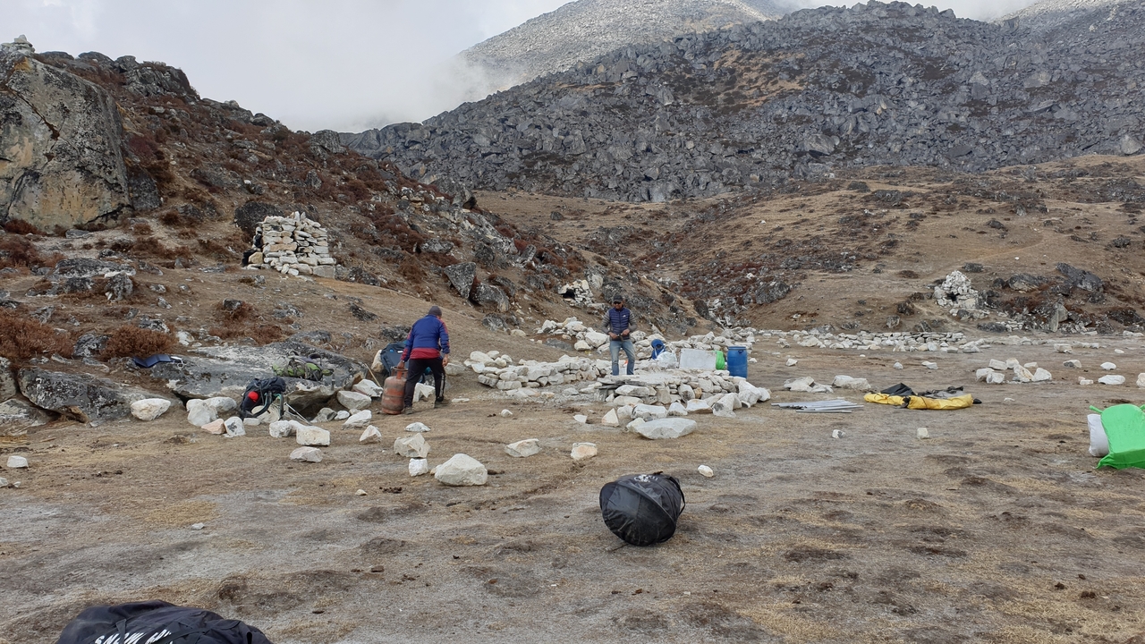 Des gens qui installent leur campement avec des collines rocheuses en arrière-plan.