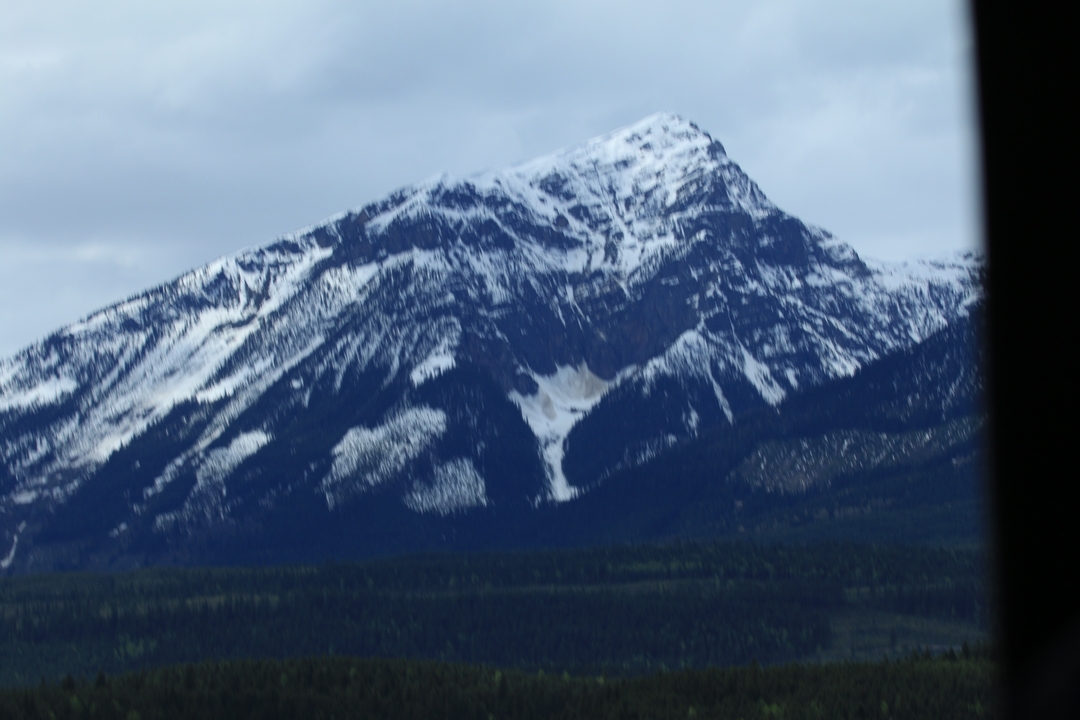 Une montagne enneigée partiellement obscurcie par une structure sombre.