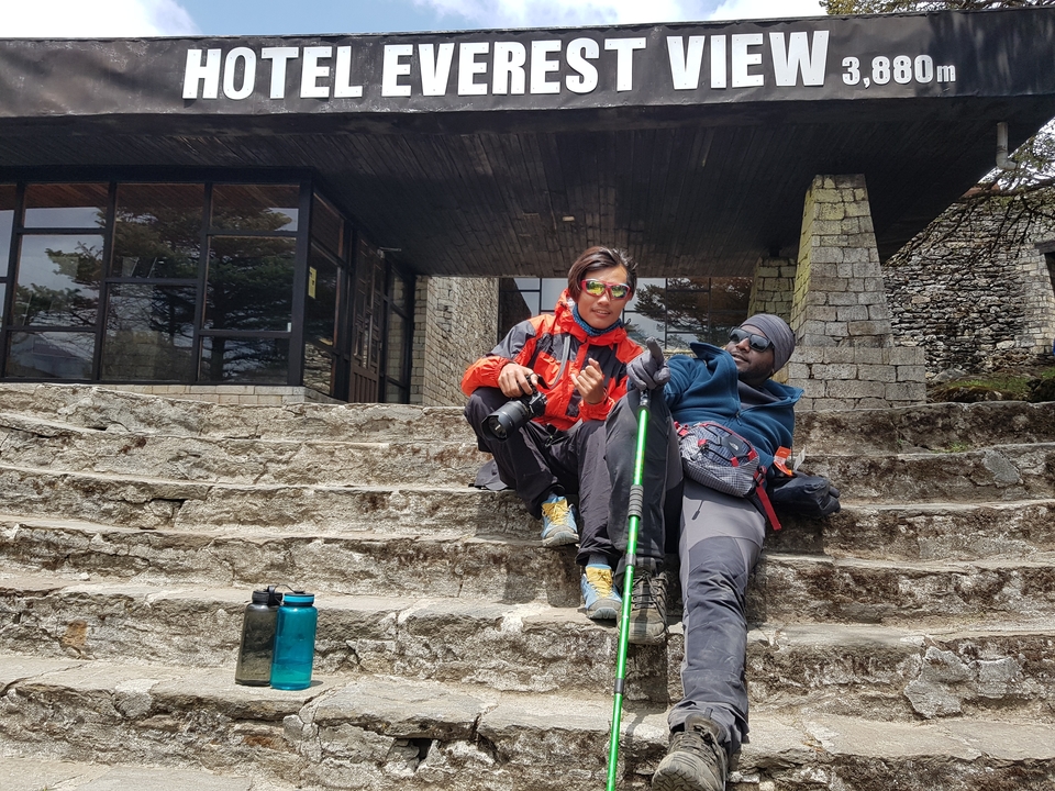 Deux hommes se reposant sur des marches avec du matériel de randonnée.