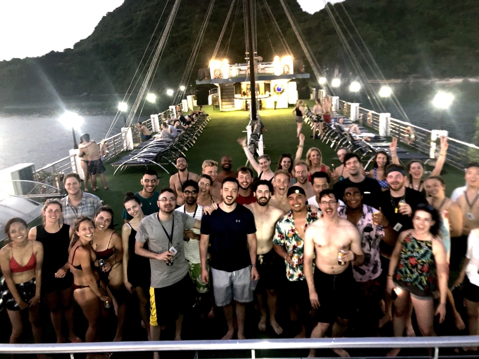 Grand groupe de personnes sur le pont d'un bateau la nuit.