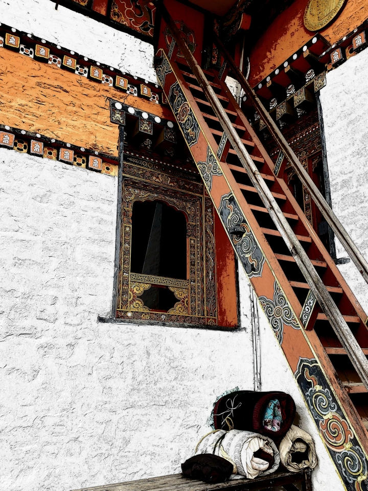 Gros plan d'une échelle décorative et d'une fenêtre au design traditionnel bhoutanais.