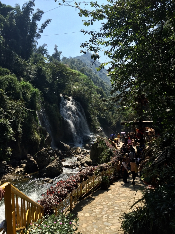 Cascade avec des touristes marchant le long d'un sentier.