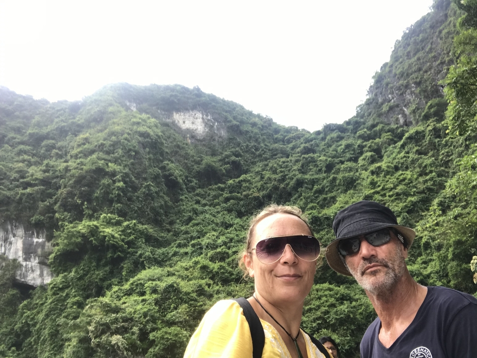 Deux personnes devant des collines verdoyantes.