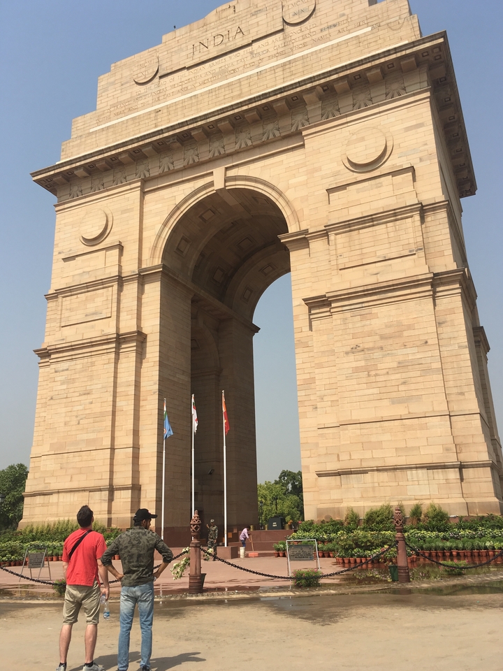 Une grande arche de pierre avec des drapeaux à la base.