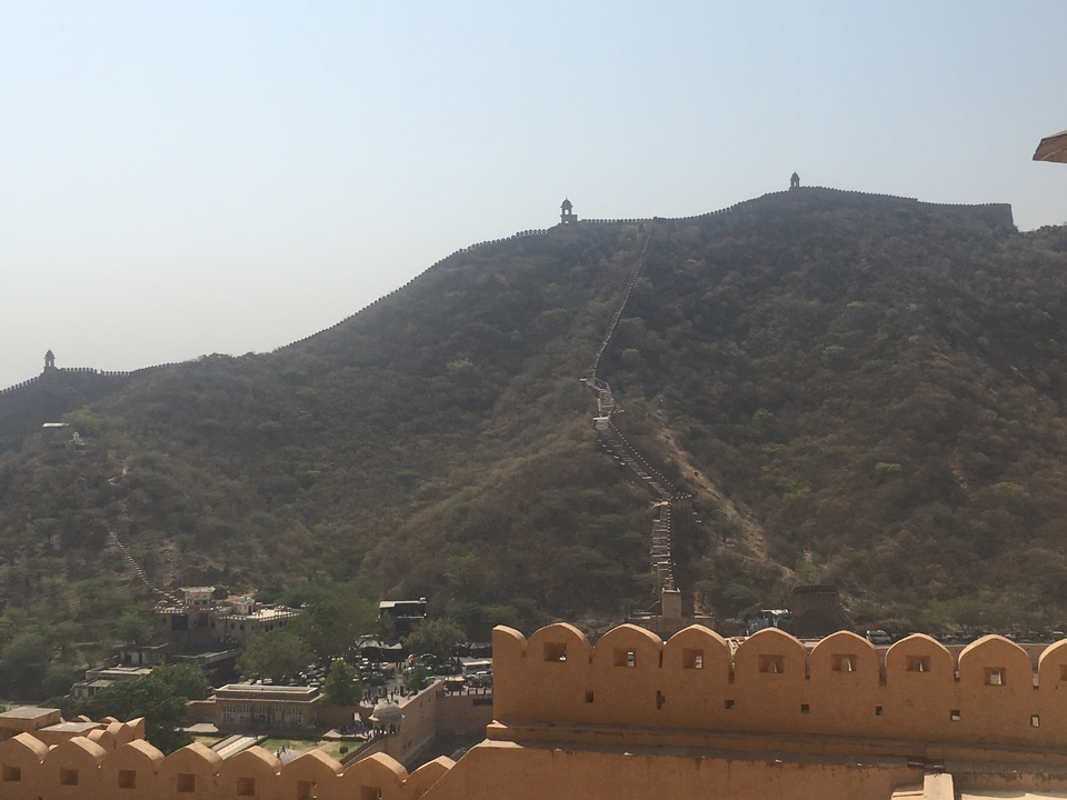 Mur fortifié longeant une colline dans un paysage pittoresque.