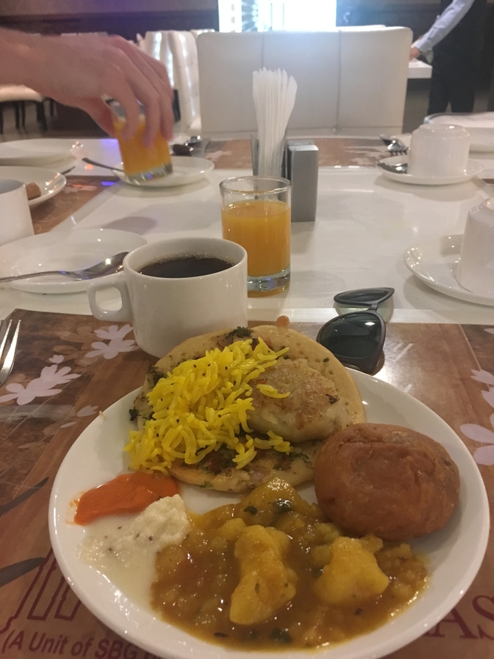 Une assiette de nourriture avec une tasse de café et du jus.