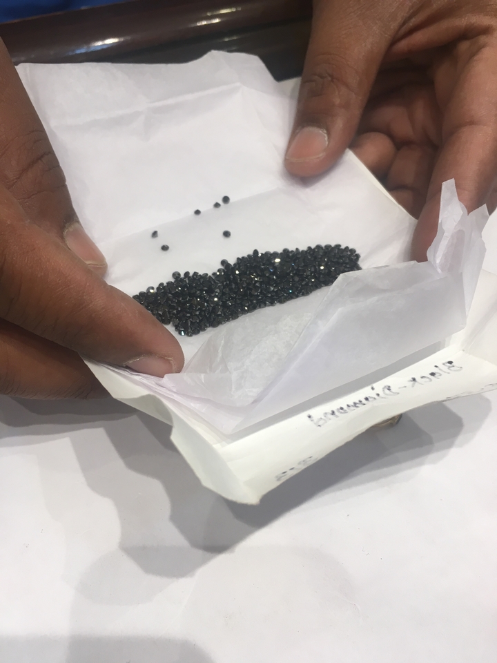 Gros plan de petites pierres noires sur papier blanc.