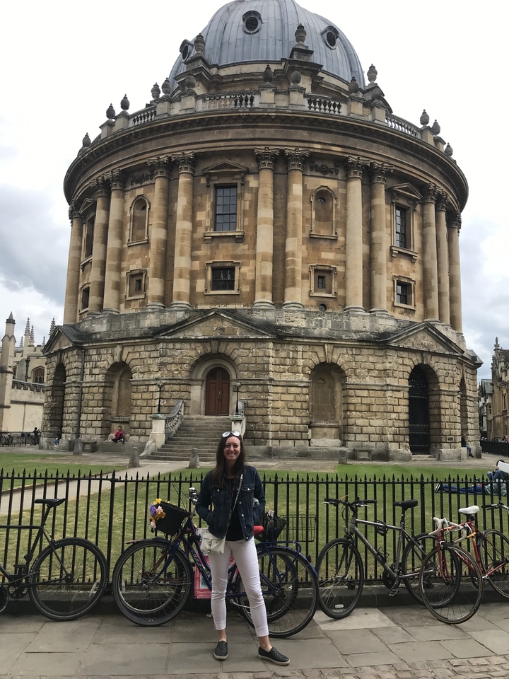 Femme devant un bâtiment historique circulaire.