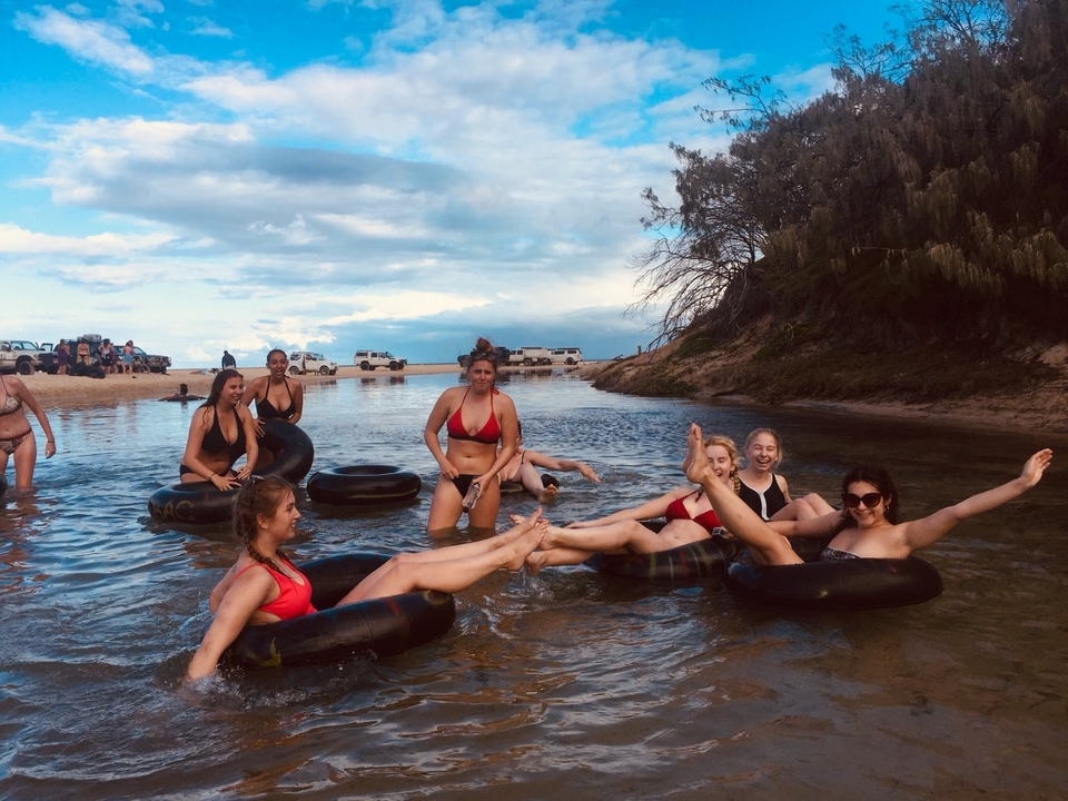 Groupe de personnes s'amusant dans une rivière avec des bouées gonflables.