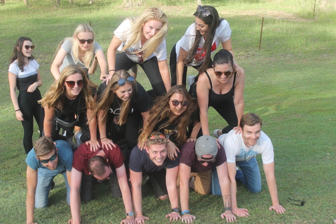 Groupe de personnes formant une pyramide humaine.