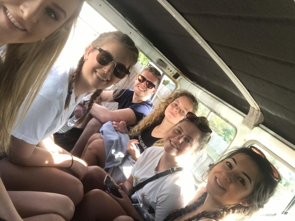 Groupe de personnes assises à l'intérieur d'un véhicule.