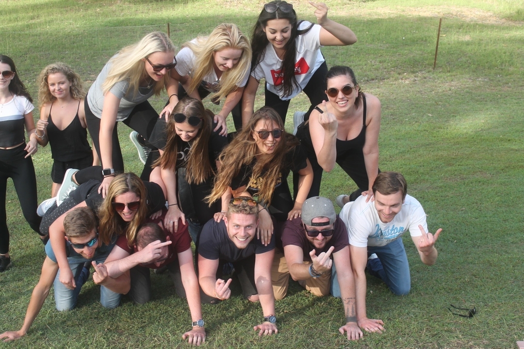 Des gens formant une pyramide humaine sur l'herbe.