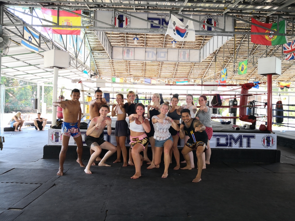 Group of people posing in a martial arts training area.