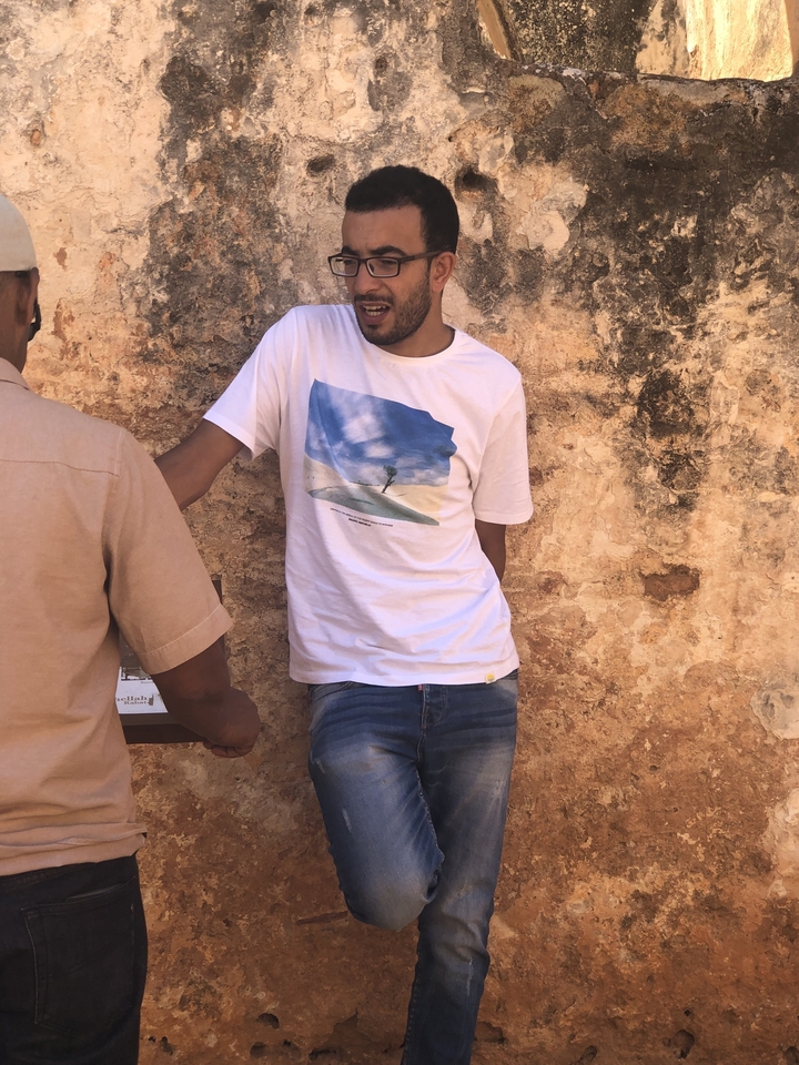 Deux personnes parlant contre un mur texturé.