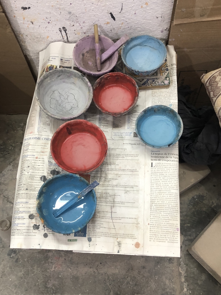 Bols de peinture avec des liquides colorés sur des journaux.