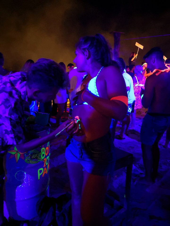 Personne se faisant peindre le corps lors d'une soirée fluo.