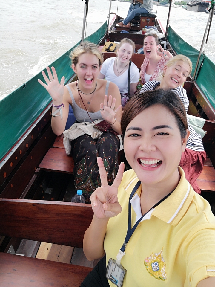 Des amis qui prennent la pose pour un selfie sur un bateau en bois.