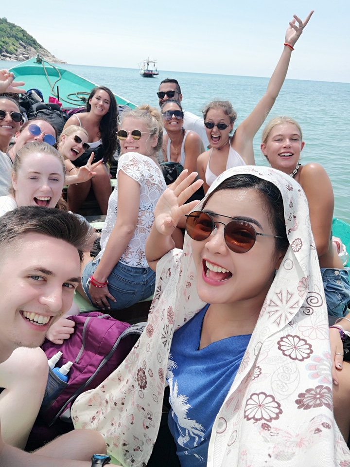 Groupe d'amis posant sur un bateau sous le soleil.