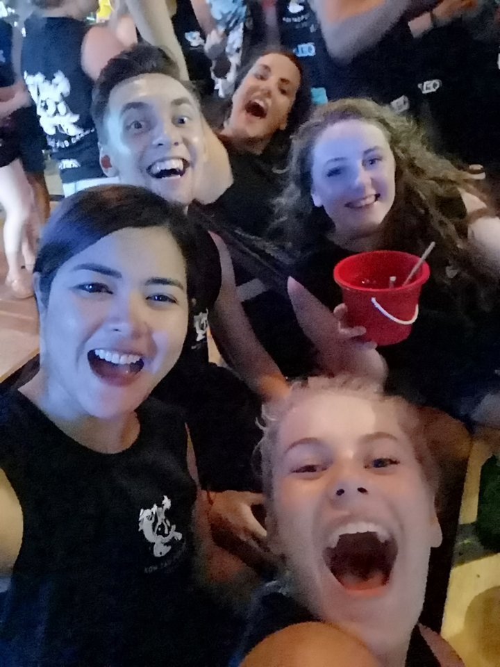 Selfie de groupe à une fête avec des lumières colorées.