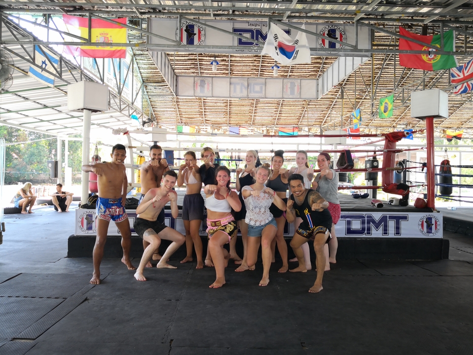 Group photo of Muay Thai trainees posing in a training area.