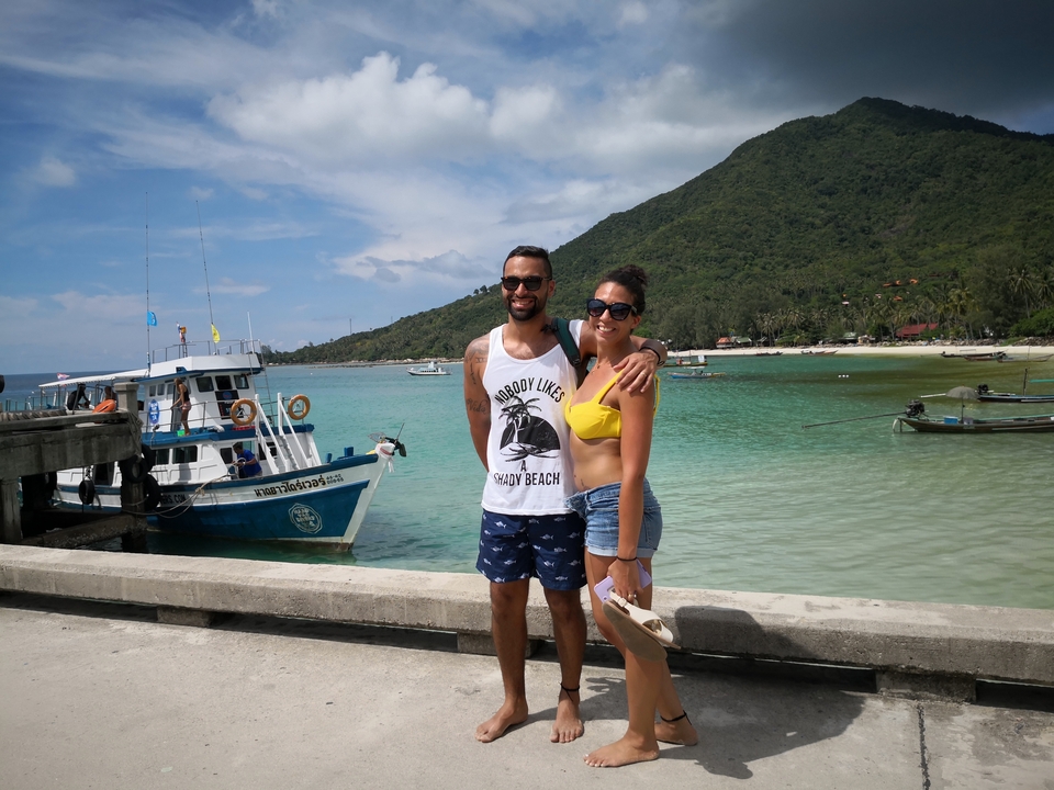 Couple standing by a harbor with boats.