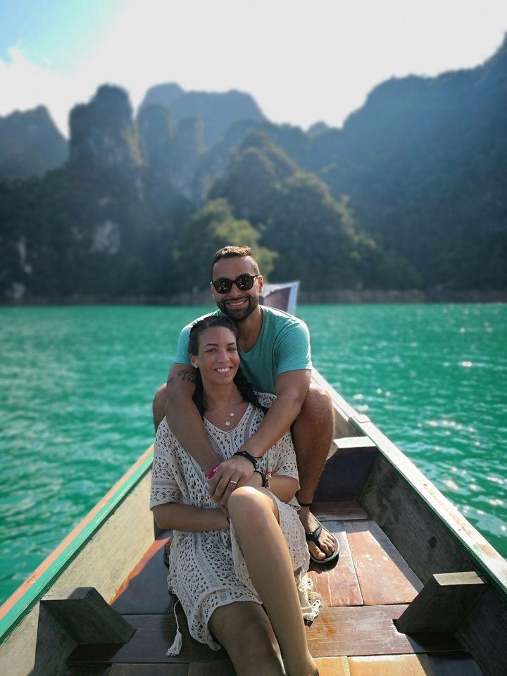 Couple sitting on a boat surrounded by blue waters.