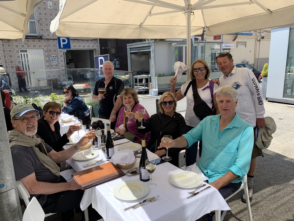 Groupe de personnes savourant du vin dans un restaurant en plein air.