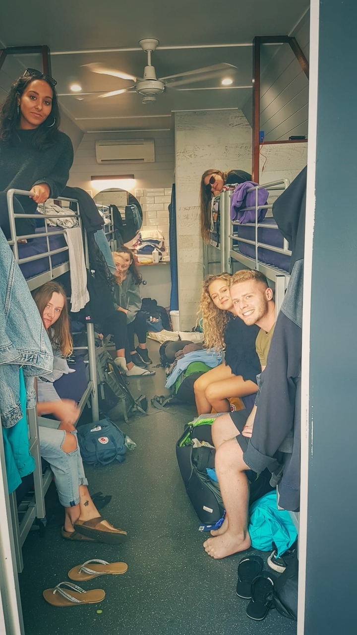 Groupe de personnes assises dans un dortoir d'auberge de jeunesse.