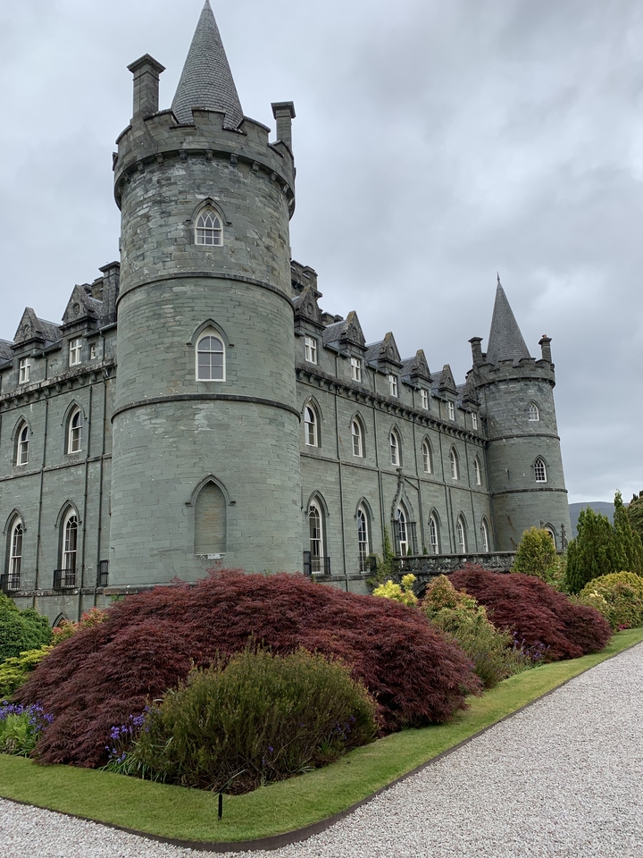 Un château avec des tourelles contre un ciel nuageux.