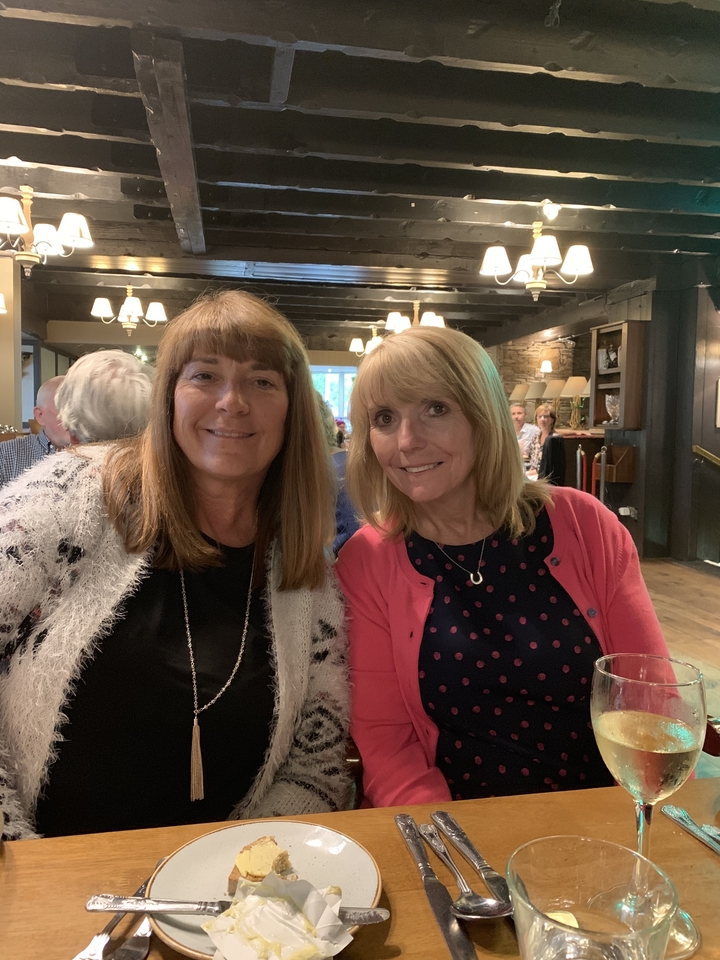 Deux femmes assises à l'intérieur à une table à manger.