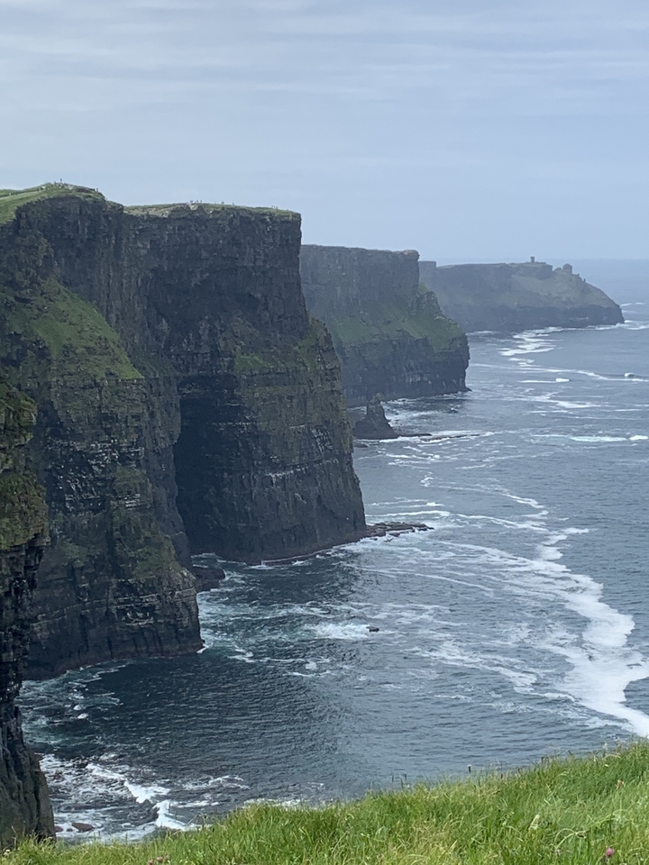 Falaises surplombant l'océan avec des vagues qui se brisent en contrebas.