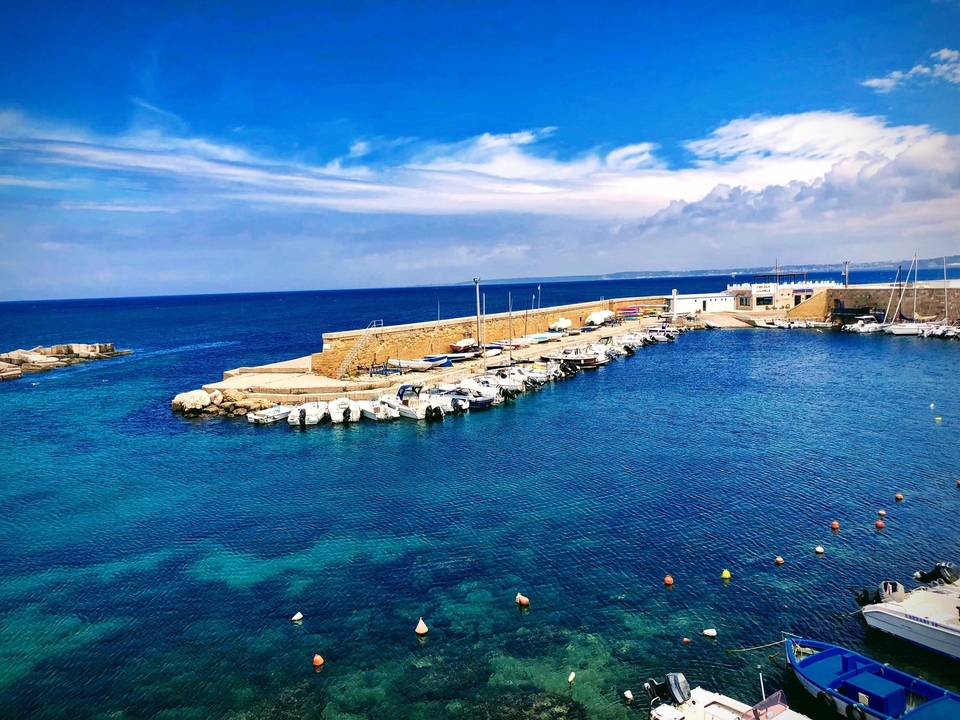 Vue du port côtier avec des bateaux amarrés le long de la jetée.